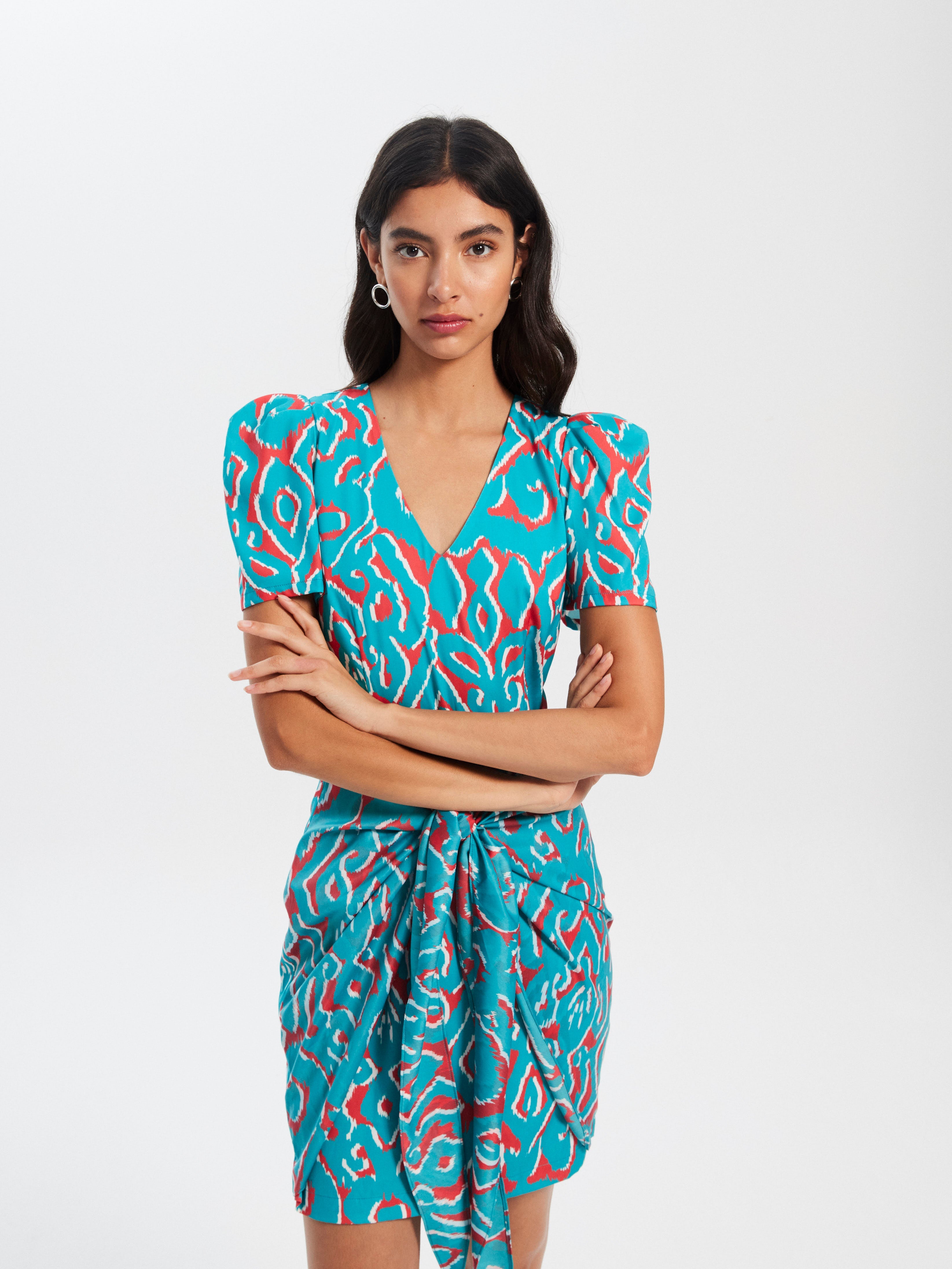 mioh | JULIETA IKAT - Vestido corto invitada boda, fiesta y evento. Vestido corto de fiesta con manga corta y lazada para ser la invitada de boda perfecta esta temporada Primavera Verano 2023. Los vestidos cortos con estampados llamativos son tendencia SS23 y una de las señas de identidad de MIOH, la marca española de vestidos de invitada de boda y fiesta.